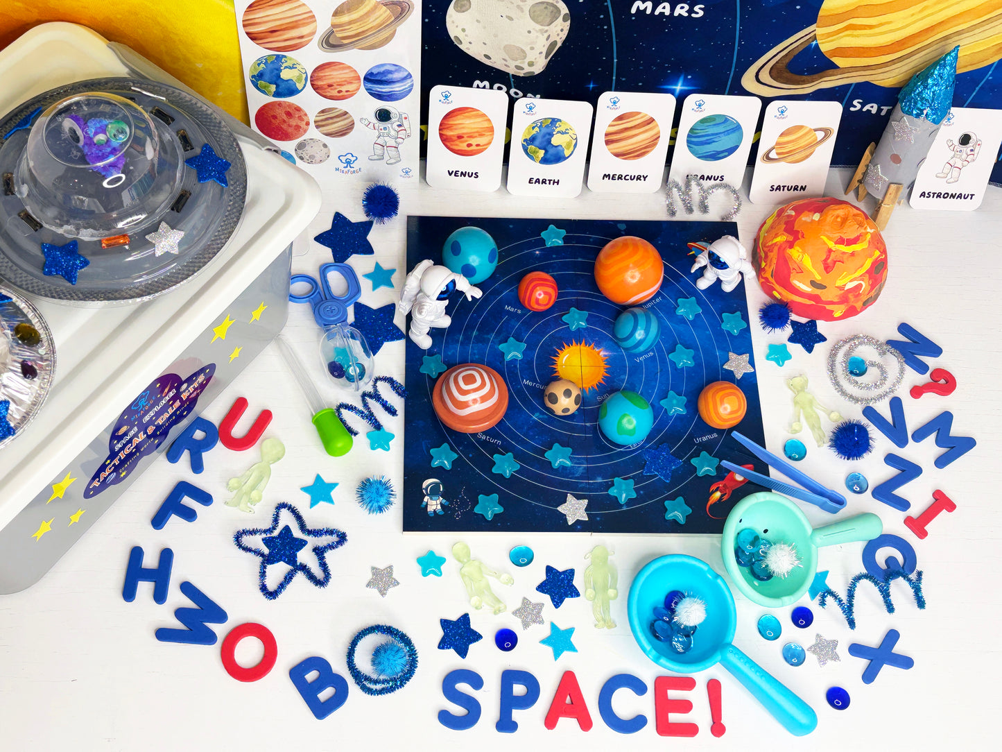Educational space-themed toys and materials on a white background